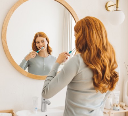 Junge Frau putzt Zähne